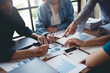 © amnaj - Business people pointing to graph and chart to analyze market, sale, balance sheet, account, net profit data to see the growth of the organization and to develop product.
