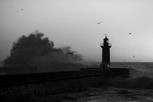 Lighthouse With Huge Wave At Atlantic, Porto, Portugal. Black And White Photo.