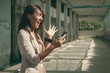 © Josu Ozkaritz - Euphoric Thai woman celebrating sport victory looking at smart phone inside building under construction. Lucky transgender person acting exultant holding mobile. On line bet win concept
