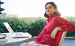 © BullRun - Smiling female blogger with laptop on terrace