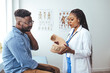 © Dragana Gordic - African American man wearing neck brace listening to doctor at hospital. Traumatologist talking to  male patient in cervical collar.