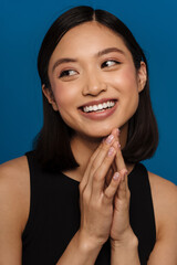 Wall Mural - Portrait of young beautiful smiling asian woman with folded hands