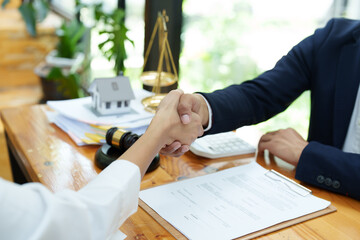 Portrait of a male lawyer shaking hands with a client to settle a court case