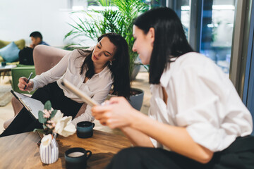 Wall Mural - Young women discussing project in office cafeteria