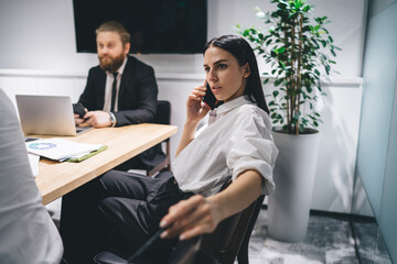 Wall Mural - Focused businesswoman speaking on smartphone in meeting room