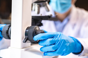 Wall Mural - biotechnology scientist using scientific microscope for research in biology medicine laboratory, equ