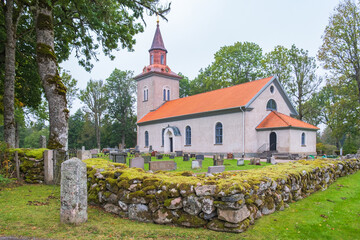 Wall Mural - Country church with a stone wall around the cemetery