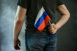 © scaliger - Man hiding Russian flag behind his back. Russophobia, hate and racism concept.