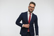 happy bearded man with glasses fixing and unbuttoning suit