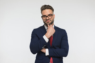 Wall Mural - thoughtful young businessman with glasses touching chin and thinking