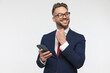 happy businessman holding phone, looking away and smiling