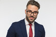 bearded businessman with glasses wearing elegant suit with red tie