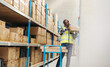 © Jacob Lund - Warehouse picker pulling a flat box from a shelf with a headset on
