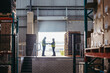 © Jacob Lund - Happy logistics workers signing a dock receipt while standing on a loading dock