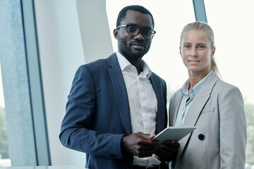 Aufkleber - Portrait of two young intercultural office managers or business partners in elegant suits looking at camera while preparing presentation