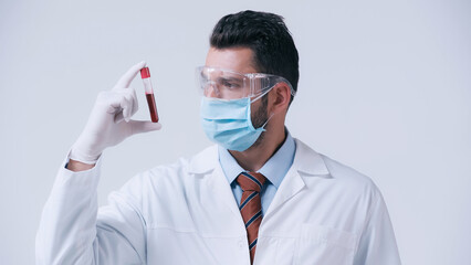 Wall Mural - brunette doctor in medical mask and latex glove holding test tube with blood isolated on grey.