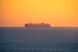 © ADDICTIVE STOCK - Sailing cargo ship in sea at sunset