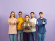 © Studio Romantic - Portrait of smiling multiethnic young people isolated on violet background show thumbs up. Happy diverse multiracial teenagers recommend good training or internship. Recommendation concept.