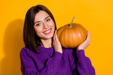 Poster - Photo of cheerful charming girl hands hold pumpkin beaming smile isolated on yellow color background