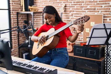 Sticker - Young african american woman musician playing spanish guitar at music studio