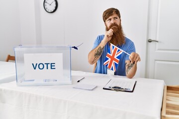 Poster - Caucasian man with long beard at political campaign election holding uk flag serious face thinking about question with hand on chin, thoughtful about confusing idea