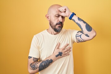 Poster - Hispanic man with tattoos standing over yellow background touching forehead for illness and fever, flu and cold, virus sick