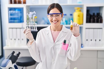 Sticker - Young brunette woman working at scientist laboratory smiling with a happy and cool smile on face. showing teeth.