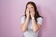 Young hispanic girl standing over pink background rubbing eyes for fatigue and headache, sleepy and tired expression. vision problem