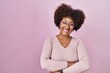 © Krakenimages.com - Young african american woman standing over pink background happy face smiling with crossed arms looking at the camera. positive person.