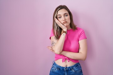 Sticker - Blonde caucasian woman standing over pink background thinking looking tired and bored with depression problems with crossed arms.