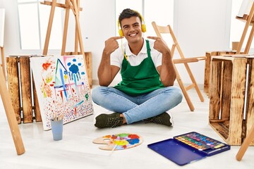 Sticker - Young hispanic man at art studio smiling cheerful showing and pointing with fingers teeth and mouth. dental health concept.