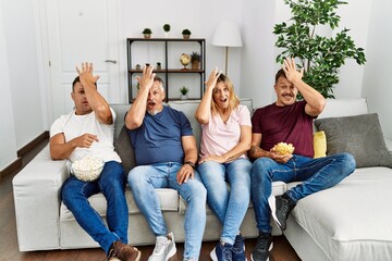 Sticker - Group of middle age people sitting on the sofa at home surprised with hand on head for mistake, remember error. forgot, bad memory concept.