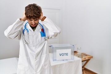 Sticker - Young arab doctor man at political election by ballot suffering from headache desperate and stressed because pain and migraine. hands on head.