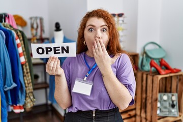 Canvas Print - Young redhead woman holding banner with open text at retail shop covering mouth with hand, shocked and afraid for mistake. surprised expression