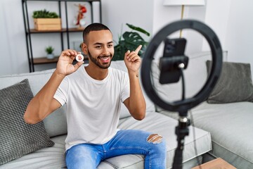 Poster - African american man recording vlog tutorial about bitcoin with smartphone at home smiling happy pointing with hand and finger to the side