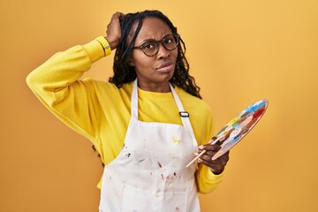 Poster - African woman holding painter palette confuse and wondering about question. uncertain with doubt, thinking with hand on head. pensive concept.