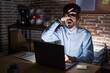 © Krakenimages.com - Young hispanic man with beard working at the office at night peeking in shock covering face and eyes with hand, looking through fingers with embarrassed expression.