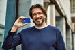 © Krakenimages.com - Middle age handsome man holding credit card at the town