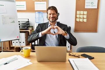 Sticker - Handsome middle age man wearing call center agent headset at the office smiling in love doing heart symbol shape with hands. romantic concept.