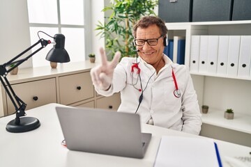 Sticker - Senior doctor man working on online appointment smiling looking to the camera showing fingers doing victory sign. number two.