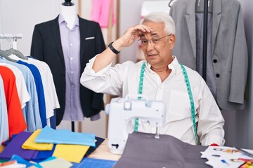 Sticker - Middle age man with grey hair dressmaker using sewing machine worried and stressed about a problem with hand on forehead, nervous and anxious for crisis