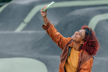 Canvas Print - latin black girl with mobile phone taking photo or selfie in the city