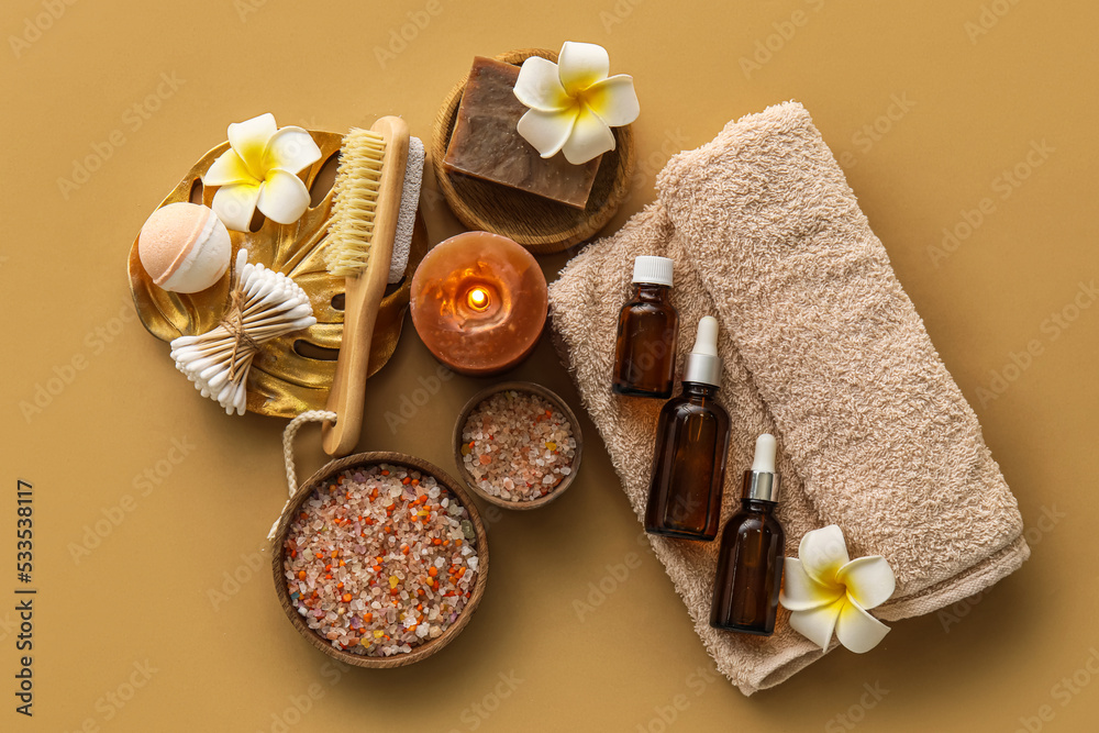 Composition with different bath supplies and burning candle on color background