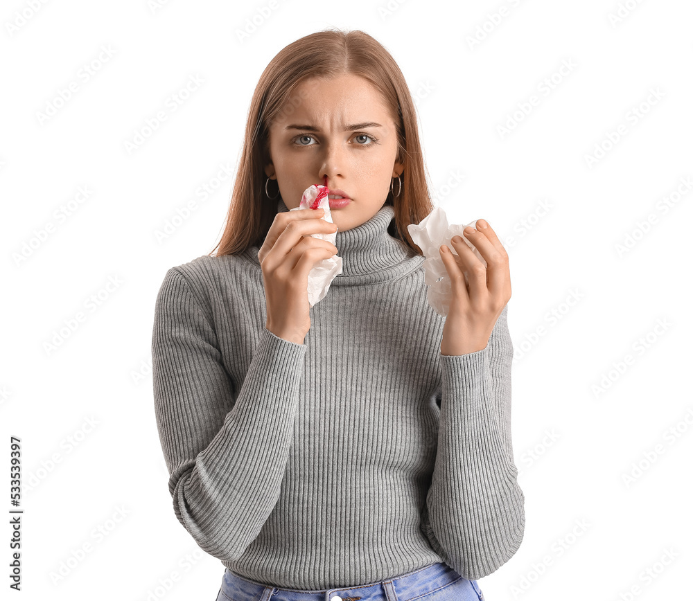 Young woman with nosebleed and tissue on white background