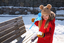 Cute Little Girl Playing With Snowball Maker Outdoors
