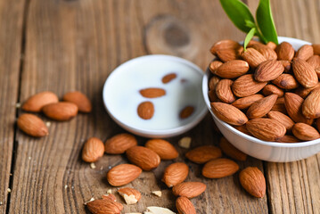 Wall Mural - Almond milk and Almonds nuts on on white bowl background, Delicious sweet almonds on the table, roasted almond nut for healthy food and snack