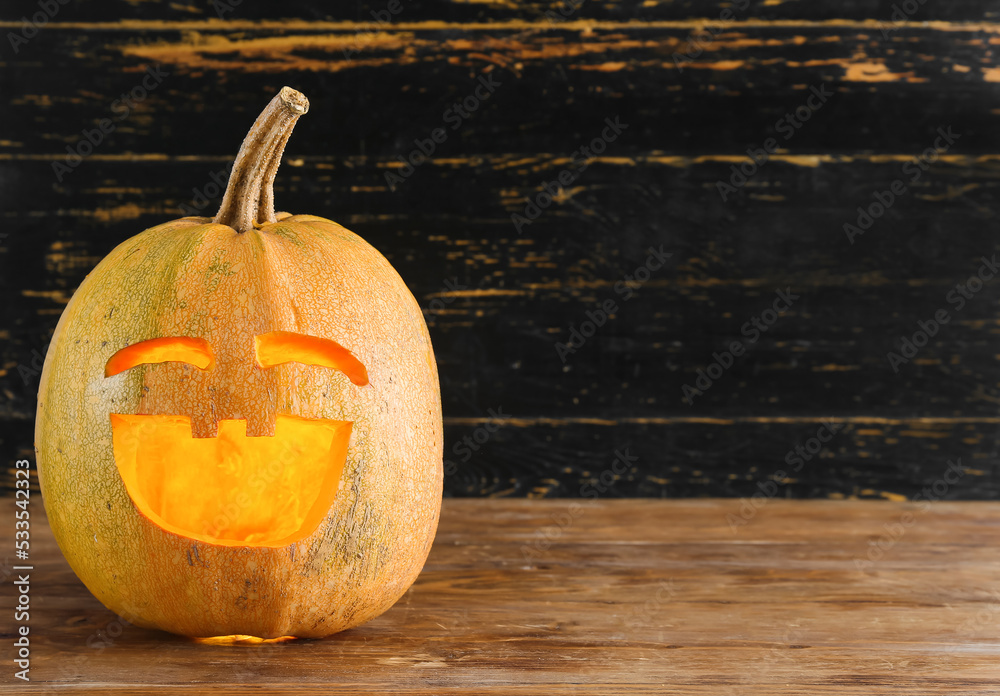 Jack-O-Lantern pumpkin on dark wooden background