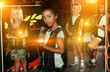 © JackF - Portrait of african preteen girl standing with laser gun on a dark lasertag arena on background with her team