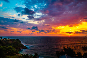 Wall Mural - beach at sunset with full colors in the sky and clouds, sun in the horizont and light reflection on the sea in puerto escondido oaxaca 