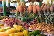 Fresh fruit and vegetable produce of pineapples, papaya and sweet potatoes on a stall at local market in a remote, tropical island destination